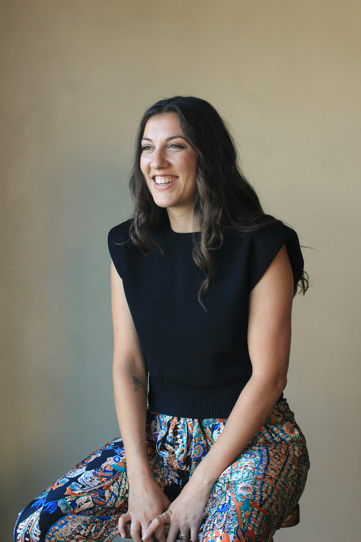 Francesca laughing while seated on a stool