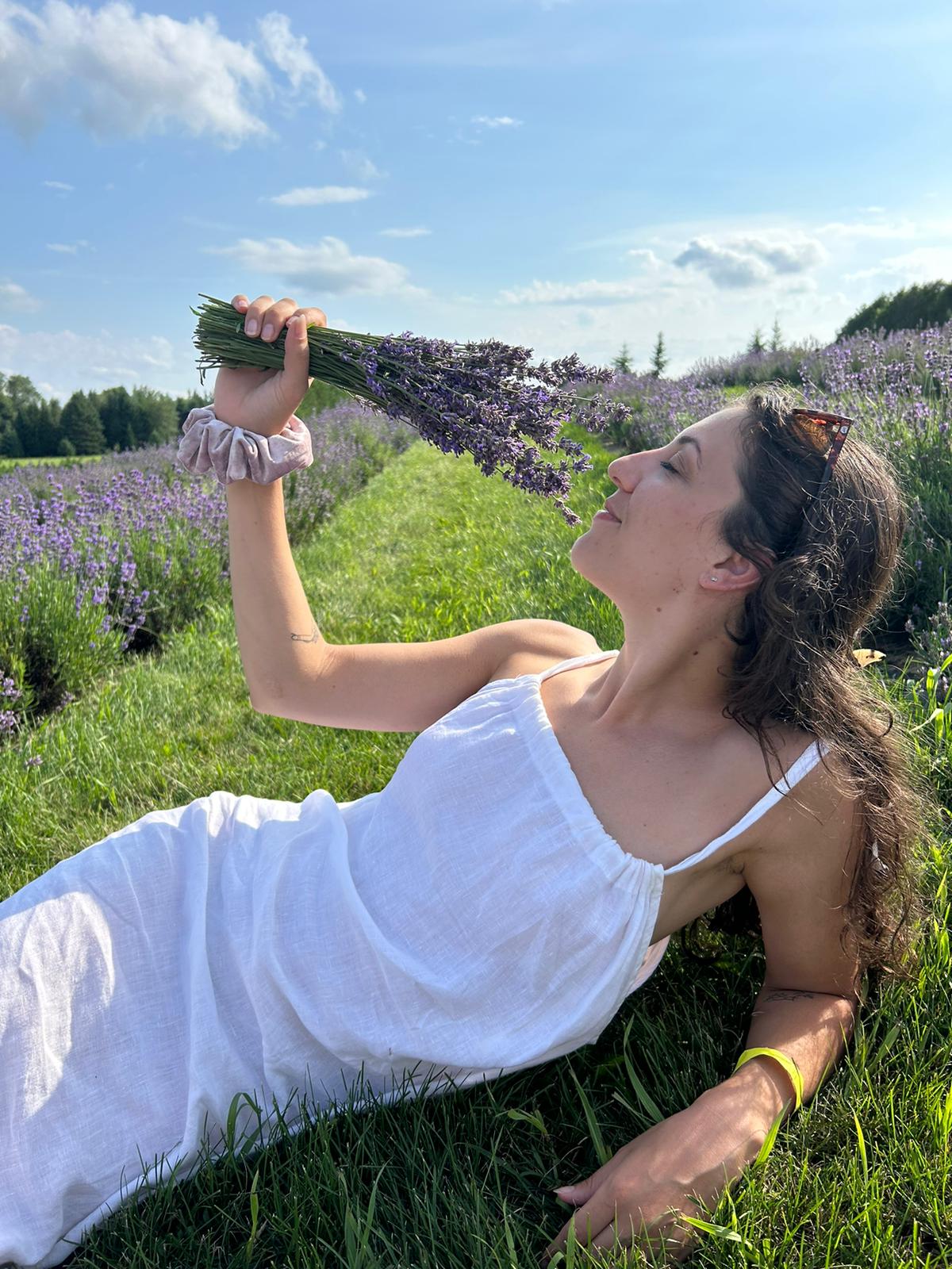 Francesca lying in a lavender field holding a bundle of lavender